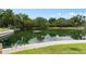Expansive pond featuring a floating dock surrounded by lush greenery and mature trees at 113 Weeping Elm Ln, Longwood, FL 32779