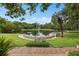 Picturesque view of the springs featuring lush greenery, mature trees, and a stone wall at 113 Weeping Elm Ln, Longwood, FL 32779