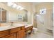 Well-lit bathroom with a large mirror, tile flooring, and a glass-enclosed shower at 17536 Se 119Th Cir, Summerfield, FL 34491