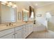 Elegant bathroom featuring double vanities, a soaking tub, and a glass-enclosed shower at 17536 Se 119Th Cir, Summerfield, FL 34491