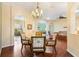 Open-concept dining room showcases a chandelier, hardwood floors, and seamless flow to other living spaces at 17536 Se 119Th Cir, Summerfield, FL 34491