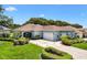 Inviting single-story home with lush landscaping, a decorative driveway, and an attached two-car garage at 17536 Se 119Th Cir, Summerfield, FL 34491