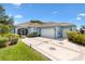 Charming single-story home with a light blue exterior, decorative driveway, and well-maintained landscaping at 17536 Se 119Th Cir, Summerfield, FL 34491