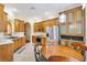 Well-lit eat-in kitchen with wooden cabinetry, stainless steel appliances, and tile flooring at 17536 Se 119Th Cir, Summerfield, FL 34491