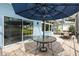 Inviting outdoor patio with a glass-topped table, umbrella, and ample seating at 17536 Se 119Th Cir, Summerfield, FL 34491