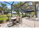 Screened patio area with outdoor seating and grill, perfect for entertaining guests at 17536 Se 119Th Cir, Summerfield, FL 34491