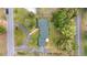 Overhead shot of a home with green roof, curved driveway, and lush surrounding landscaping in a verdant setting at 1866 Ne 39Th Ct, Ocala, FL 34470