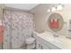 Bathroom featuring floral curtain, oval mirror, sink with vanity, and three-bulb light fixture at 1866 Ne 39Th Ct, Ocala, FL 34470