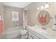 Bathroom with floral curtain, oval mirror, sink with vanity, and three-bulb light fixture at 1866 Ne 39Th Ct, Ocala, FL 34470