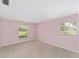 Bedroom with two windows, light pink walls, and carpet at 1866 Ne 39Th Ct, Ocala, FL 34470