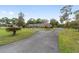 Circular driveway leading to a brick home with lush green lawns and mature trees in a serene setting at 1866 Ne 39Th Ct, Ocala, FL 34470