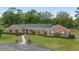 Beautiful brick home with a green roof, landscaped garden, and a paved walkway to the entrance at 1866 Ne 39Th Ct, Ocala, FL 34470