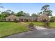 Charming brick home featuring a well-manicured lawn, mature landscaping, and a welcoming walkway to the front door at 1866 Ne 39Th Ct, Ocala, FL 34470