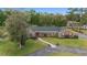 Attractive brick home featuring green shutters, a red door, lush lawn, and mature trees in a peaceful neighborhood at 1866 Ne 39Th Ct, Ocala, FL 34470