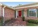 Close-up of the home's front door, showcasing brick detail and green shutters at 1866 Ne 39Th Ct, Ocala, FL 34470