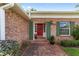 Close-up of the home's front door, showcasing brick detail and green shutters at 1866 Ne 39Th Ct, Ocala, FL 34470