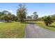 Long driveway leads up to this brick home, with lush green yard and mature trees at 1866 Ne 39Th Ct, Ocala, FL 34470