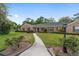 Brick home with green shutters, red front door and a well-maintained lawn at 1866 Ne 39Th Ct, Ocala, FL 34470