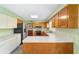 Bright kitchen features stainless steel appliances, wooden cabinetry, and a gray tile floor at 1866 Ne 39Th Ct, Ocala, FL 34470