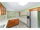 Kitchen with tile flooring, stainless steel refrigerator, light countertops, and wooden cabinets at 1866 Ne 39Th Ct, Ocala, FL 34470