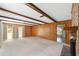 Spacious living room with wood paneling, beamed ceiling, and access to other rooms at 1866 Ne 39Th Ct, Ocala, FL 34470