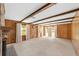 Bright living room featuring wood paneling, beamed ceiling, fireplace, and natural light at 1866 Ne 39Th Ct, Ocala, FL 34470