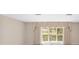 Bright and airy living room featuring neutral walls, large window, and decorative valance at 1866 Ne 39Th Ct, Ocala, FL 34470