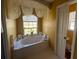 Bright bathroom featuring a large soaking tub beneath a window, offering a relaxing retreat at 1961 Sw 170Th Loop, Ocala, FL 34473