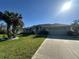 Well-maintained home with a two-car garage, arched windows, and a beautifully landscaped yard with palm trees at 1961 Sw 170Th Loop, Ocala, FL 34473