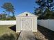 Exterior view of shed features neutral paint, ramp, and a clear view of surrounding fenced in yard at 1961 Sw 170Th Loop, Ocala, FL 34473