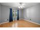 A bedroom features hardwood floors, neutral paint, a ceiling fan, and curtains at 2199 Se 175Th Ter, Silver Springs, FL 34488