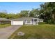 Charming single-story home with manicured lawn, blue exterior, and attached two-car garage at 2199 Se 175Th Ter, Silver Springs, FL 34488