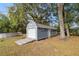A blue storage shed with a ramp in a spacious backyard with large, mature trees at 2199 Se 175Th Ter, Silver Springs, FL 34488