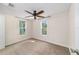 Bright bedroom with neutral carpet, ceiling fan, and natural light from two windows at 2300 Ne 49Th St, Ocala, FL 34479