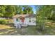 Charming home featuring a bright red front door, cozy porch, and well-maintained lawn at 2300 Ne 49Th St, Ocala, FL 34479