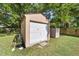 Garage exterior shows a secure door, tidy space, and a practical storage shed alongside a patch of green lawn at 2300 Ne 49Th St, Ocala, FL 34479
