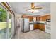 Well-lit kitchen featuring tile floors, wood cabinets, and modern appliances, and a view to the backyard at 2300 Ne 49Th St, Ocala, FL 34479