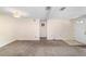 Carpeted room with white walls, ceiling fan, and front door, well-lit by large windows at 2300 Ne 49Th St, Ocala, FL 34479