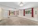Spacious living room with neutral carpet, white walls, large windows and a front door on the left at 2300 Ne 49Th St, Ocala, FL 34479