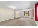 Bright living room with neutral carpet and patterned curtains, and the front door to the right at 2300 Ne 49Th St, Ocala, FL 34479