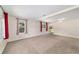 Bright, carpeted living room with neutral walls and large windows dressed with patterned curtains at 2300 Ne 49Th St, Ocala, FL 34479