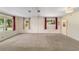 Large living room with neutral walls and carpet features big windows with patterned curtains at 2300 Ne 49Th St, Ocala, FL 34479