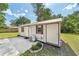 View of a small outbuilding, with a compact AC unit, complemented by a small adjacent garden bed at 2300 Ne 49Th St, Ocala, FL 34479