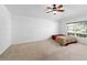 Bedroom with neutral carpet, ceiling fan, and large window providing natural light at 3011 Se 46Th Ave, Ocala, FL 34480