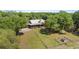 Spacious property featuring a log home with a metal roof, surrounded by sprawling greenery and mature trees at 3360 Se 183Rd Avenue Rd, Ocklawaha, FL 32179