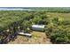 Aerial view of a warehouse with surrounding lush green trees with a lake in the far background at 3360 Se 183Rd Avenue Rd, Ocklawaha, FL 32179