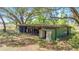 Rustic barn featuring open storage, green siding, and a corrugated metal roof surrounded by large trees at 3360 Se 183Rd Avenue Rd, Ocklawaha, FL 32179