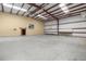 Spacious barn interior with concrete flooring, open ceiling, and a door to Cabin Pub at 3360 Se 183Rd Avenue Rd, Ocklawaha, FL 32179