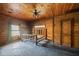 Cozy log cabin bedroom with a wooden bed frame and natural wood walls and ceiling fan at 3360 Se 183Rd Avenue Rd, Ocklawaha, FL 32179