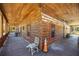 View of the wooden porch that surrounds the log cabin, offering an invitation to rest and relax outdoors at 3360 Se 183Rd Avenue Rd, Ocklawaha, FL 32179